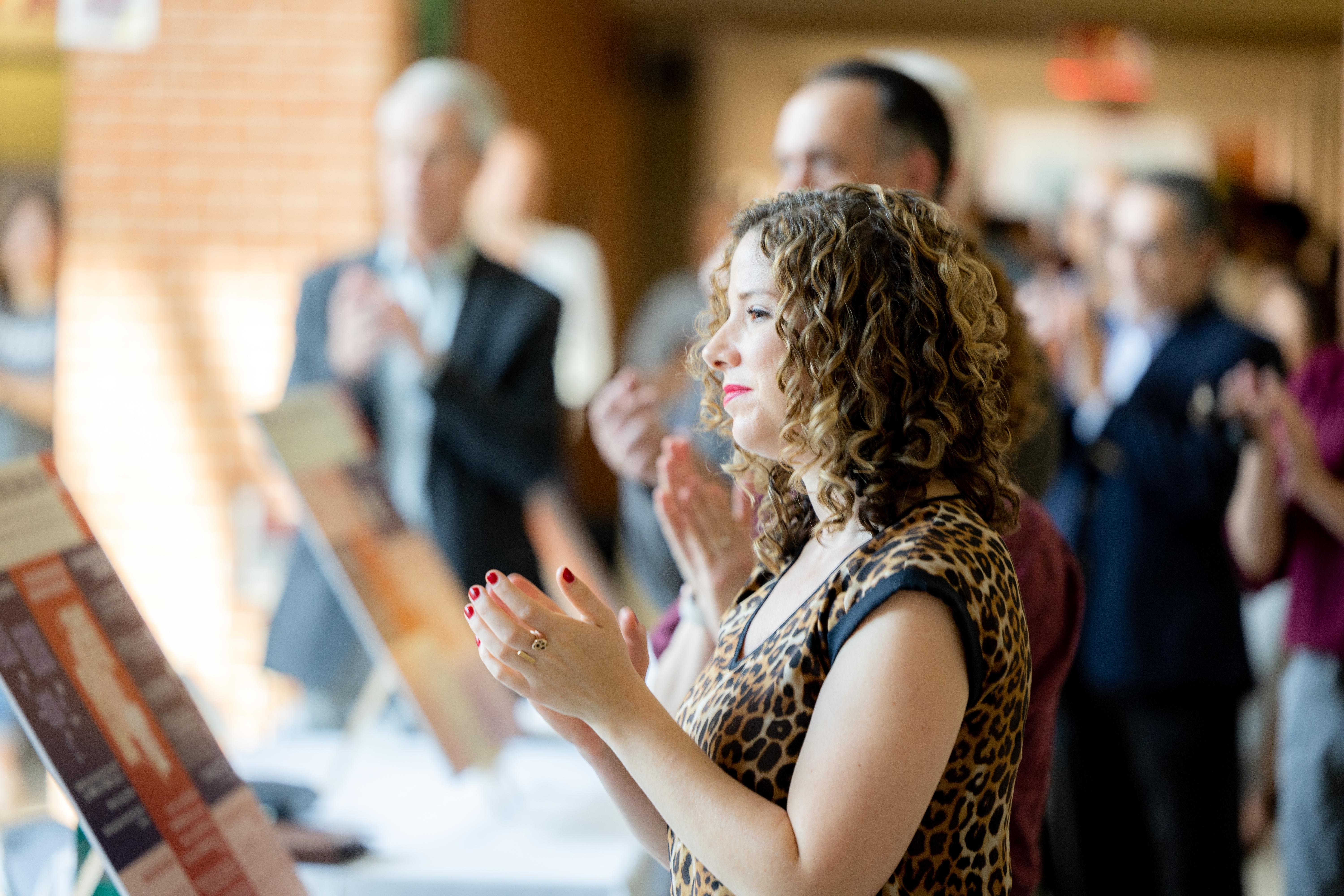 Kathryn Vomero Santos claps among audience at the Trinity Tomorrow Close Out event.