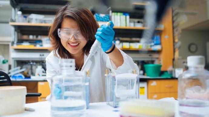 Liezelle Lopez in a lab coat in the chemistry lab 