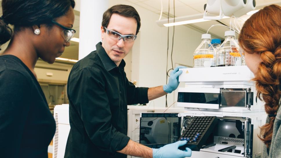 Adam Urbach works with students in his 化学 lab