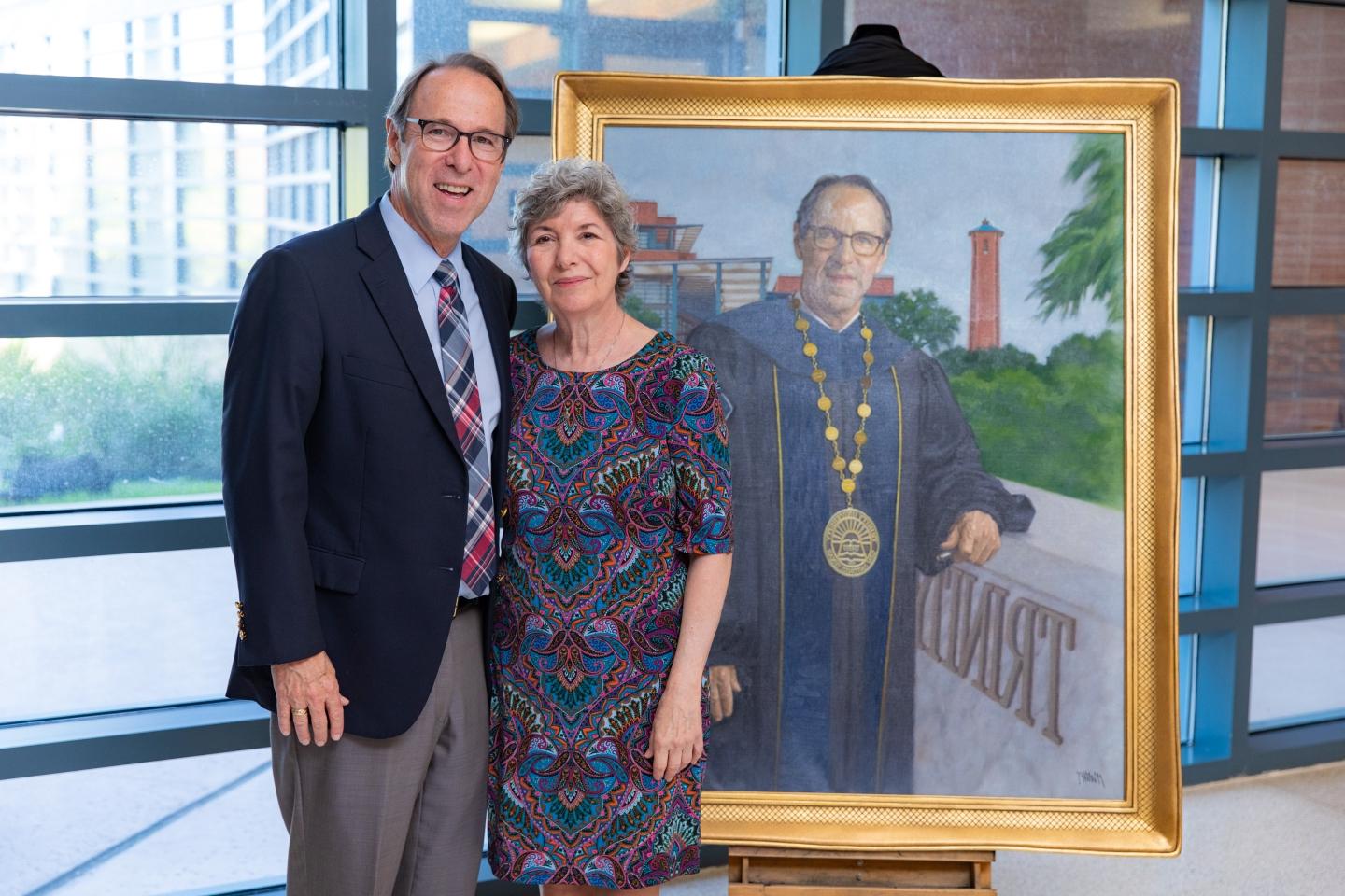 Danny and Kimberly Anderson stand next to Danny's presidential portrait