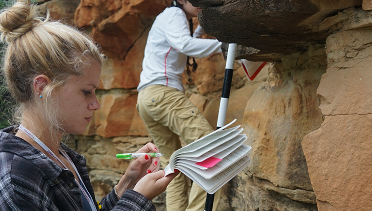 Student Studying A Rock In Nature