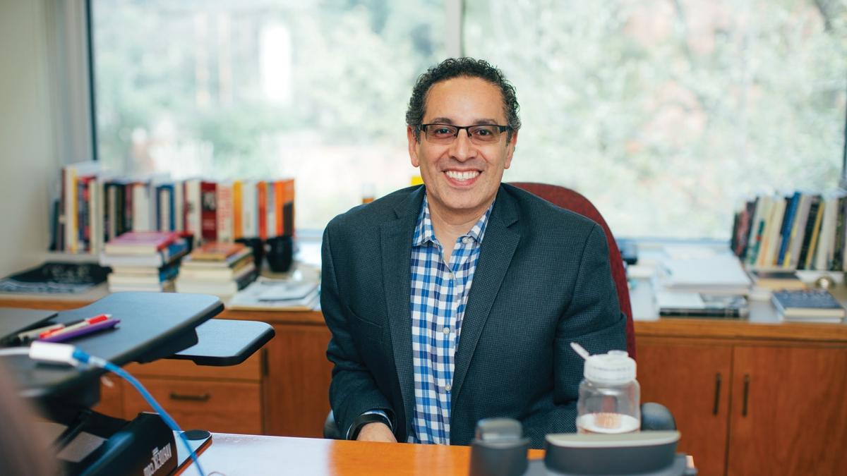 Juan Sepulveda sits at desk